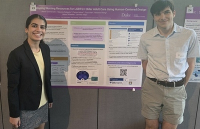 Two team members stand with their poster at the Bass Connections Showcase.