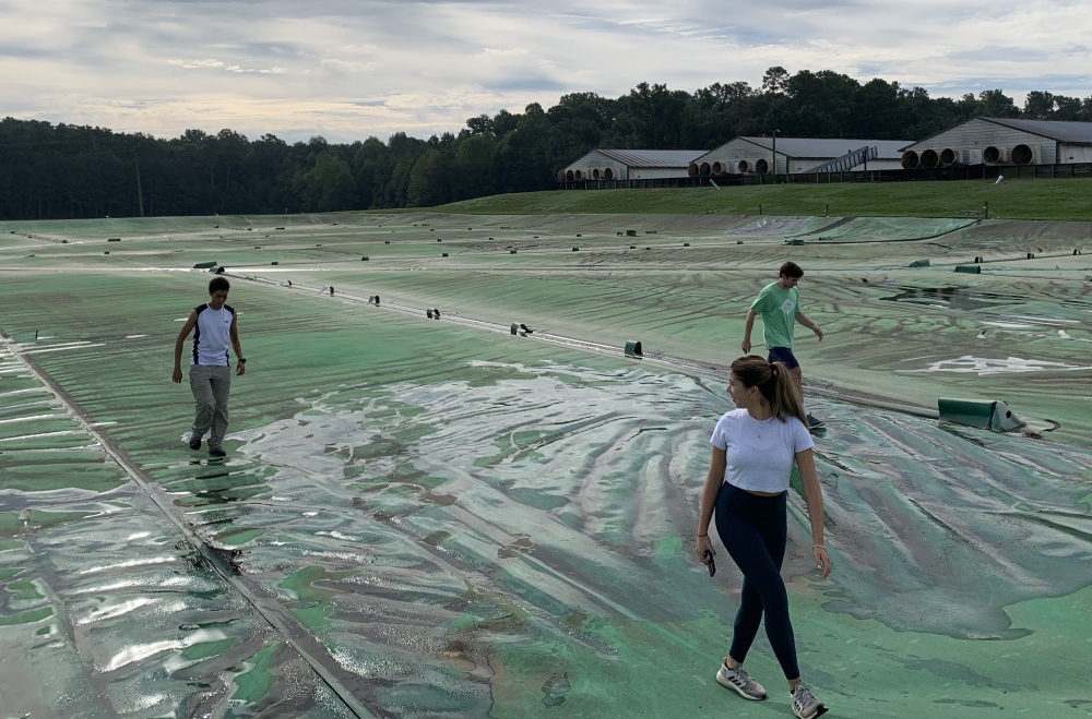Students walking on covered waste lagoon.