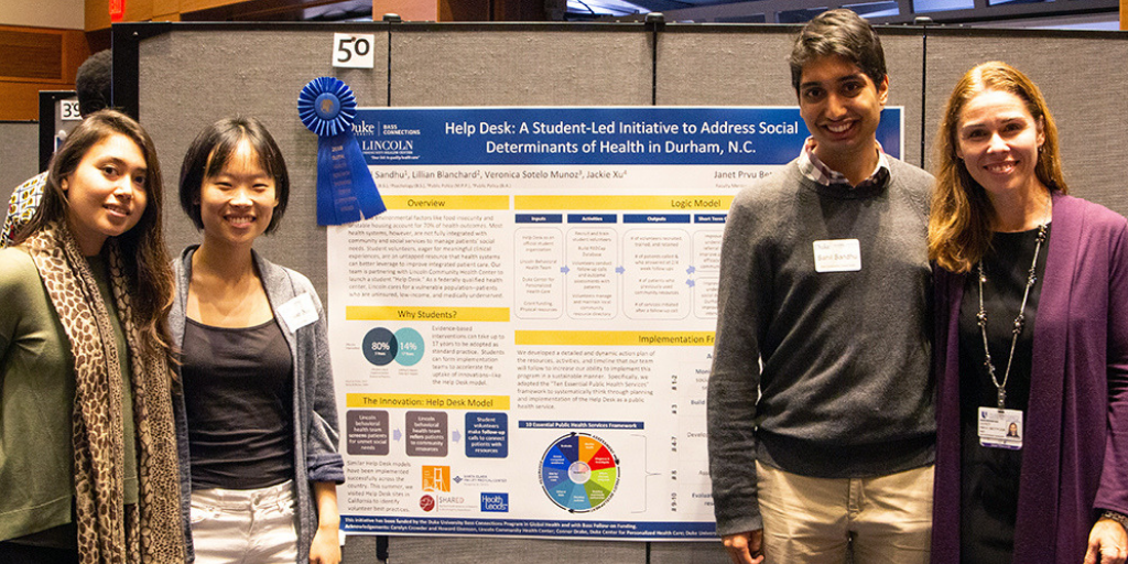 Team members standing in front of their project poster. 