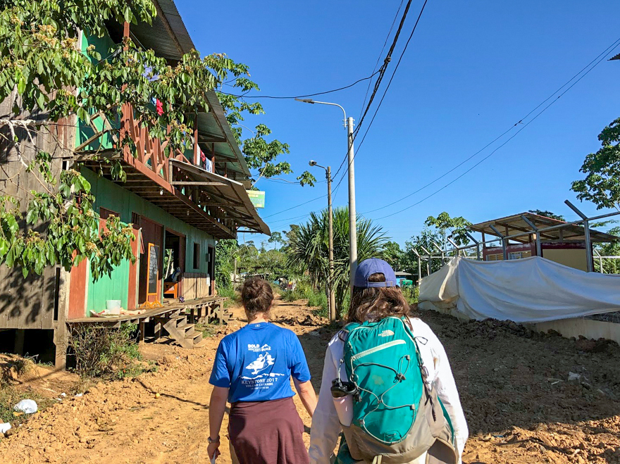 My mentor Jackie (an Ecology Ph.D. candidate) and I walking through the mining town to collect chickens. Credit: Fernanda Machicao.