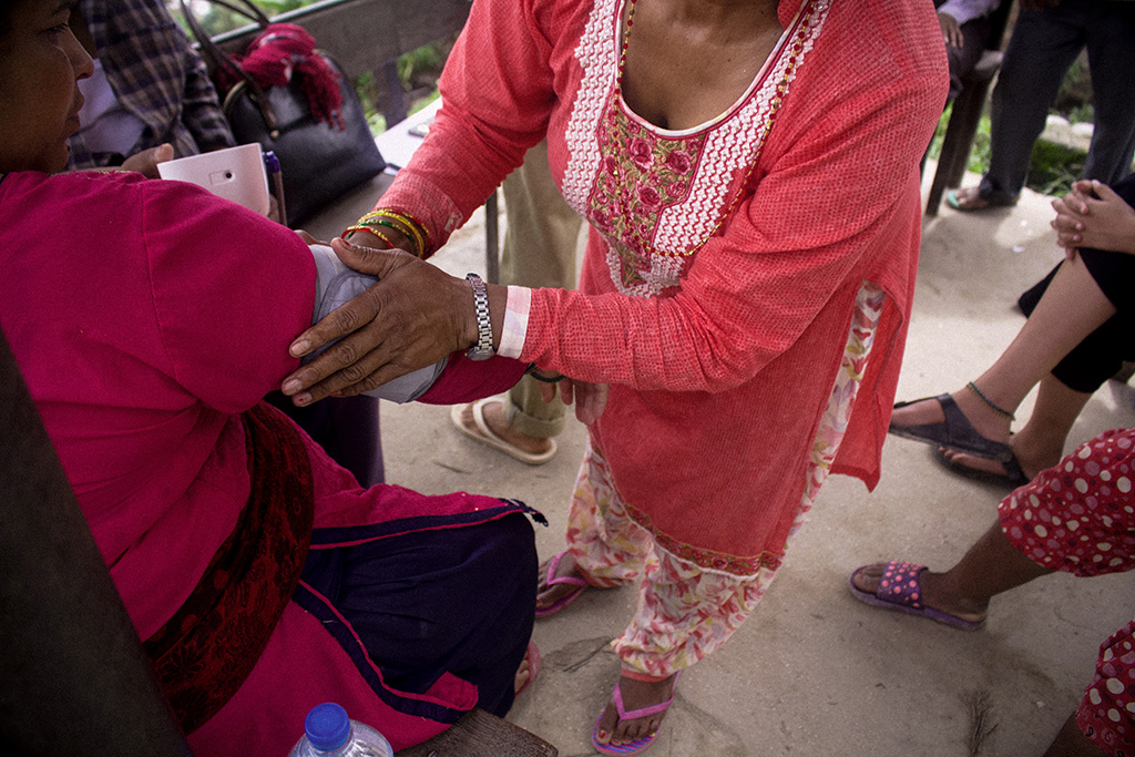 A female community health volunteer in Panchkhal, Kavrepalanchok District, Nepal, checks a local community member’s blood pressure.