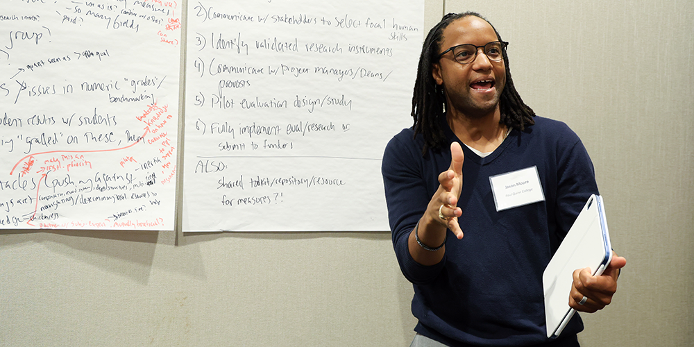 Man speaks to symposium participants while gesturing