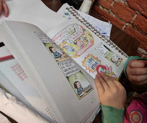 Child reading book in Spanish.