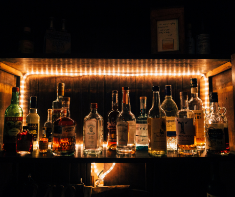 Bottles of alcohol on a shelf in a bar.