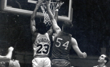 Claiborne jumps to block an opponent's shot in a basketball game.
