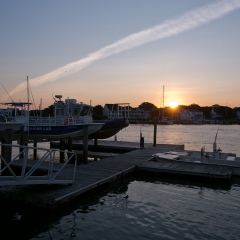 Boats in a harbor at sunset.