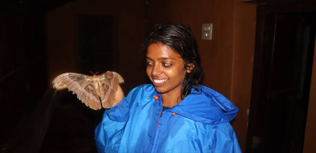 Satagopan holds a large moth.