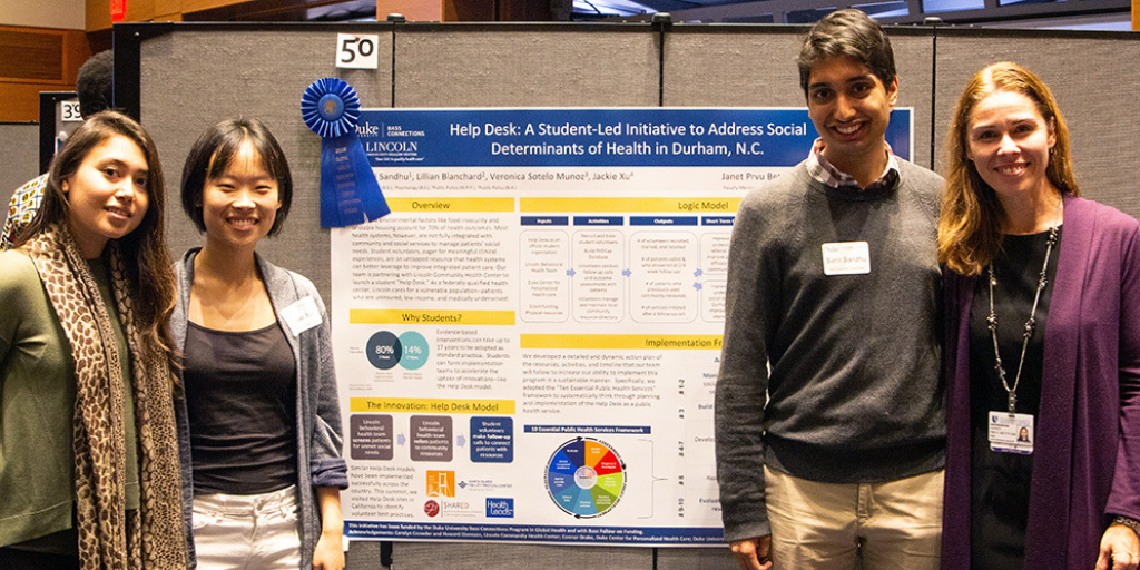 Four people standing in front of a poster