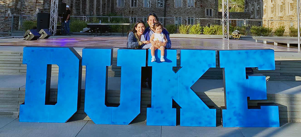 Edgar with family in front of Duke sign.